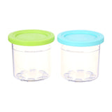 Ninja CREAMi Pints & Storage Lids, 2 Pack, XSKPLID2CD — Two clear Ninja CREAMi pint containers with lime and aqua lids standing side by side on a plain background