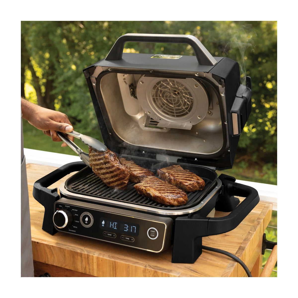 Ninja Woodfire 7-in-1 Outdoor Grill & Smoker, Electric, OG701 — Ninja Woodfire OG701 outdoor electric grill in grey with the lid open showing the grill grate, front three-quarter view